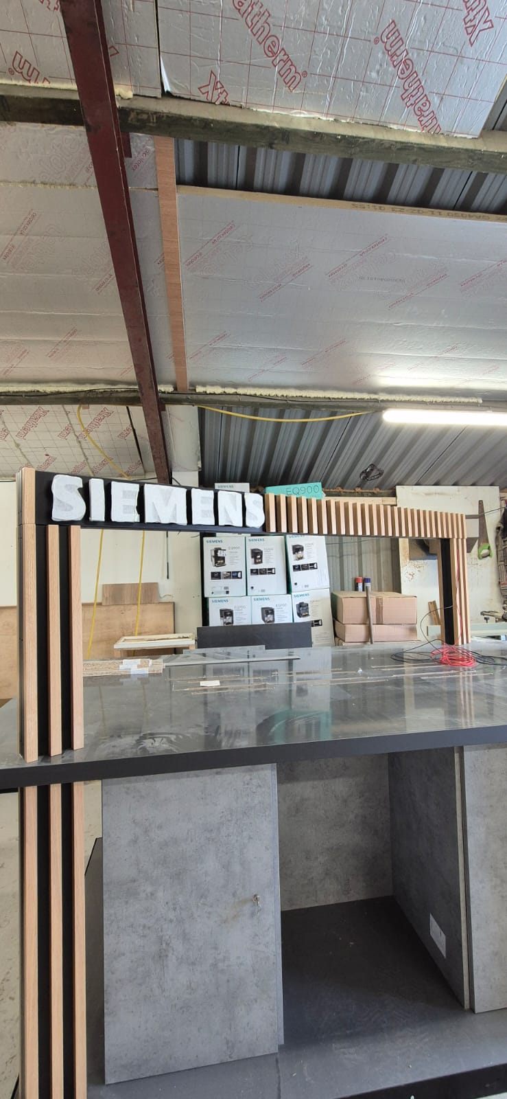 Siemens coffee display under construction with 3D brand lettering being placed